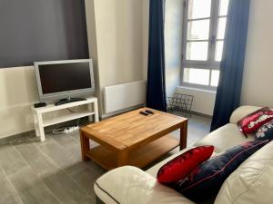 een woonkamer met een bank en een salontafel bij 45m² rez-de-chaussée au calme centre-ville in Mayenne