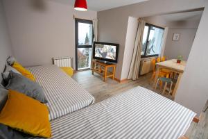 1 dormitorio con 2 camas, mesa y escritorio en Apartamento Mitre en San Carlos de Bariloche