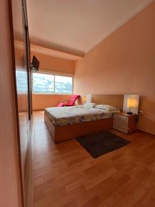 a bedroom with a bed and a desk and a window at J´S Place in Lubango