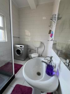 uma casa de banho com um lavatório e uma máquina de lavar roupa em J´S Place em Lubango