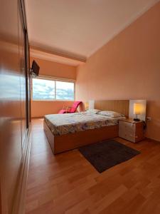 ein Schlafzimmer mit einem großen Bett und einem Fenster in der Unterkunft J´S Place in Lubango