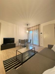 uma sala de estar com um sofá e uma mesa em Cortemaggiore 4D Luxury-Flexrent Abissinia em Riccione