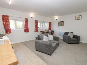 a living room with two couches and a table at Newfield Apartment 2 in Broughton in Furness