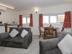 a living room with two couches and a table at Newfield Apartment 2 in Broughton in Furness