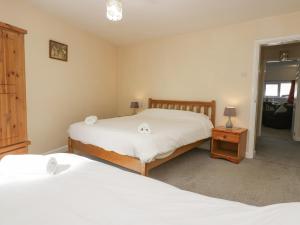 a bedroom with two beds and a table with a lamp at Newfield Apartment 2 in Broughton in Furness