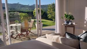 a living room with a couch and a sliding glass door at Knysna Estate Lagoon - Garden Apartments- Secure Estate - off the grid in Knysna