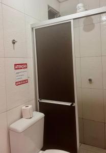 a bathroom with a toilet with a glass shower door at Hotel Santiago Juazeiro in Juazeiro do Norte