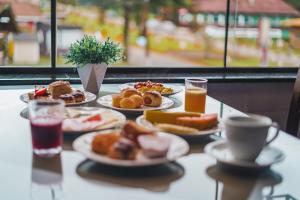 a table topped with plates of food and drinks at Chalés Galinha Da Roça in Monte Verde