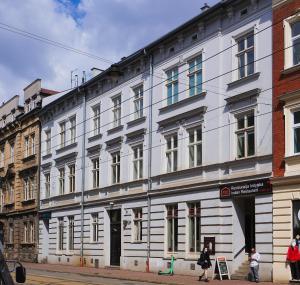 biały budynek po stronie ulicy w obiekcie Starowiślna VIP Apartamenty JACUZZI w Krakowie