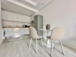 een keuken met 2 stoelen en een tafel in een kamer bij Double Studio B106 StayInn by Cosmopolis in Ştefăneştii de Jos