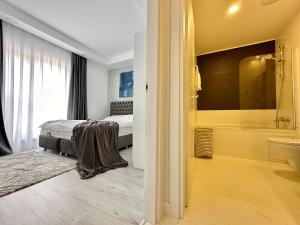 een slaapkamer met een bed en een badkamer met een bad bij Double Studio B106 StayInn by Cosmopolis in Ştefăneştii de Jos