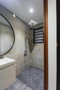 a bathroom with a shower with a sink and a mirror at Coco Lagon accès plage in Saint-Paul +14 photos