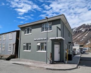 a gray building with a door in a street at The Ísafjörður Inn in Ísafjörður