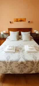a large bed with two white towels on it at Casa Rural El Abuelo Anselmo in Segovia