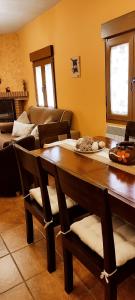 a living room with a wooden table and chairs at Casa Rural El Abuelo Anselmo in Segovia