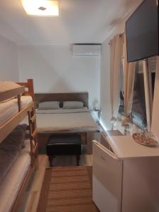 上米拉諾瓦茨的住宿－Guest House Etno selo Trbović，小房间设有一张床和一张书桌及电视