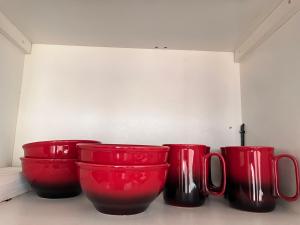 quatro vasos vermelhos sentados num balcão numa sala em Apartamentos Carmela # 3 em Siguatepeque