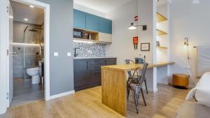 a kitchen with a counter and a table in a room at Hostellicious Studio in Faro