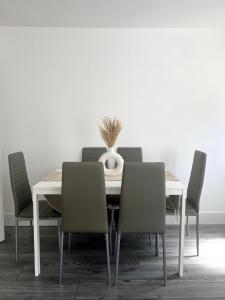 una mesa de comedor con sillas y un jarrón. en No 29 - Beautiful 4-Bed House en Liverpool