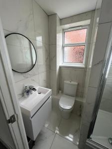 a bathroom with a toilet and a sink and a mirror at No 29 - Beautiful 4-Bed House in Liverpool