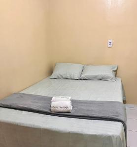 a bed with a towel on top of it at Hotel Santiago Juazeiro in Juazeiro do Norte