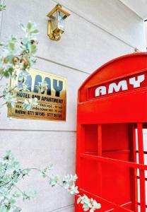順化的住宿－Amy Hotel Hue，墙上有标牌的红色电话亭