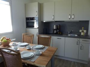 a kitchen with a wooden table and a kitchen with white cabinets at Bernsteinland Barth in Barth +21 photos