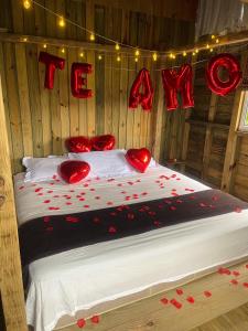 um quarto com uma cama com corações vermelhos em Pousada Vale da Magia em Praia do Rosa
