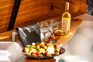 um prato de frutas e copos de vinho numa mesa em Karaöz Sapphire Bungalows em Kumluca