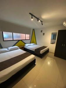 a hotel room with two beds and a tv at 33 Hotel Bulerias in Medellín