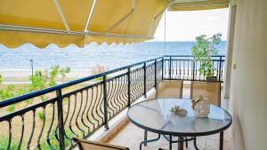 Un balcón con una mesa de cristal y vista al mar. en Svetlana Seaview Villa, en Nea Karvali