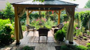 a gazebo with chairs and a table in a garden at The 1885 Suites in Picton