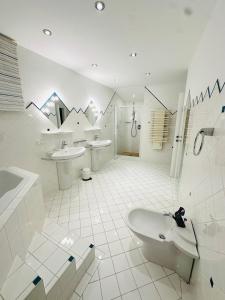ein weißes Badezimmer mit einer Badewanne und einem Waschbecken in der Unterkunft LUXURY STAY SALZBURG City in Salzburg