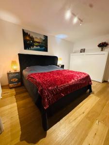 a bedroom with a bed with a red blanket on it at LUXURY STAY SALZBURG City in Salzburg