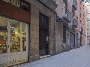 an empty street with a store window on a building at Ola Living Gaudi in Barcelona