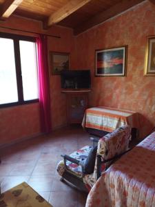 Habitación con 2 camas y una silla. en Appartamento Il Salice, en Casa Minnina