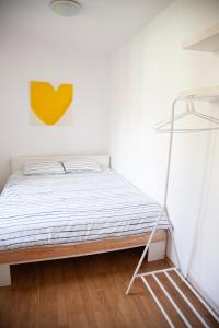 1 dormitorio con 1 cama con una foto amarilla en la pared en Rosa di Pirano en Piran
