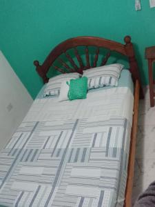 a bed with a wooden headboard and a green wall at Dpto LUDIM 1 in Federación