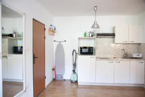 cocina con armarios blancos y suelo de madera en Rosa di Pirano, en Piran