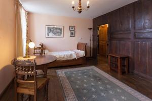 1 dormitorio con 1 cama, mesa y sillas en La Vieille Auberge, en Peyrelevade