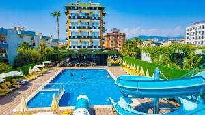 a swimming pool with chairs and a hotel at DE MARE FAMILY Hotel in Konaklı