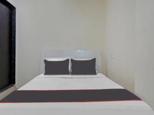 a bed with two pillows on it in a room at Collection O Brahma Residency in Chinchiwad +18 photos