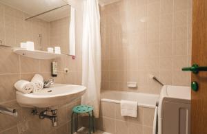 łazienka z umywalką i wanną w obiekcie Appartements Pulverer w mieście Bad Kleinkirchheim