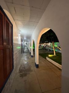 um corredor vazio de um edifício com um arco em Pousada Puerta Del Sol Rio das Ostras em Rio das Ostras