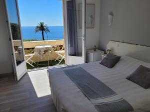 - une chambre avec un lit et une vue sur l'océan dans l'établissement Villa Esmeralda, aux Issambres