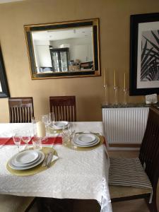 a table with plates and glasses and a mirror at House Rose 1 in Prescot