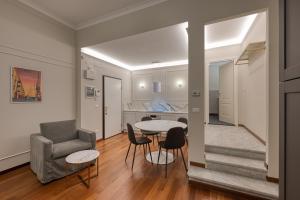 a living room with a couch and a table and chairs at Via Emilio Bensa - Le Case di Bart in Genoa