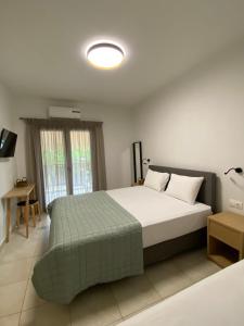 ニキティにあるGeorgoudi Apartmentsのベッドルーム1室(大型ベッド1台、緑の毛布付)