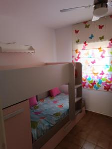 a bedroom with a bunk bed with butterflies on the wall at Chalet Calan Bosch in Cala en Bosc +7 photos
