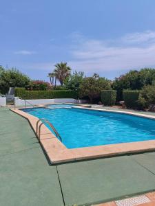 a swimming pool with a bench next to it at Chalet Calan Bosch in Cala en Bosc